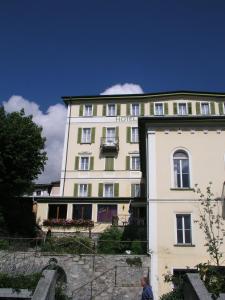 Ein Mann steht vor einem Gebäude. in der Unterkunft Hotel Quellenhof in Scuol