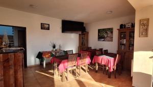 a dining room with a table and chairs and a television at Vila Lesana in Nová Lesná