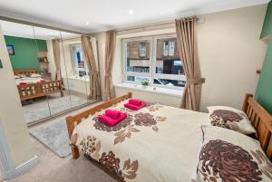 een slaapkamer met 2 bedden en een raam bij Argyll Apartments - George Street, Oban in Oban