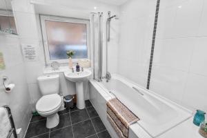 een witte badkamer met een toilet en een wastafel bij Argyll Apartments - George Street, Oban in Oban