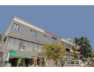 um edifício alto com carros estacionados em frente em Hotel Hill View, Vadodara, Gujarat em Vadodara