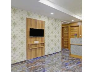 um quarto com uma televisão de ecrã plano na parede em Hotel Hill View, Vadodara, Gujarat em Vadodara