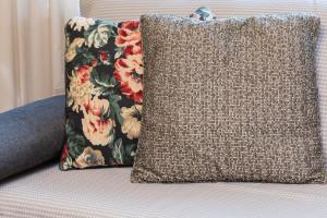 a pillow sitting on a couch with a floral pillow at Apartment Os Jagiellońskie in Poznań by Renters in Poznań