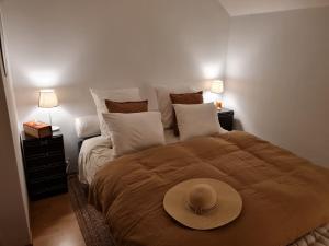 a bedroom with a bed with a hat on it at Bed vue sur vallée de la Meuse Namur in Bouge