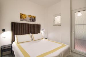 een slaapkamer met een groot wit bed met 2 kussens bij Delicious 2 Bed Room Apartment and Garden by YH in Rome