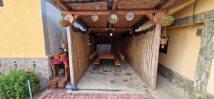 a patio with a wooden table in a building at CASA ANDREEA in Novaci-Străini
