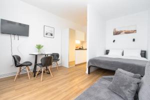 1 dormitorio con 1 cama, mesa y sillas en Apartamenty Piastowska, en Nysa