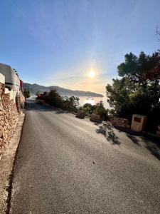 an empty road with the sun setting in the distance at Casa Caracol in La Herradura