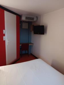 サン・テティエンヌ・デュ・ルヴレにあるHOTEL PREMIERE CLASSE Rouen Sud Oisselのベッドルーム1室(ベッド1台付)、テレビが備わるアパートメントです。