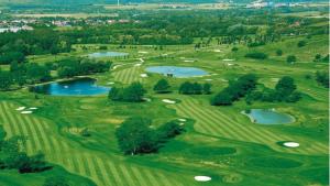 an overhead view of a golf course with three ponds at Le Vie del Castello in Francavilla Bisio