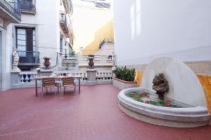 バルセロナにあるOla Living Portaferrissaの噴水、テーブル、椅子が備わる中庭