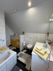 a bathroom with a tub and a toilet and a sink at Ferienwohnung am Rosenberg in Stockach