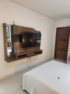 a bedroom with a flat screen tv on a wall at Villa Gardem in Aracaju