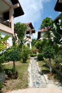 a walkway in front of a building with trees at Baan Jasmin Village in Choeng Mon Beach