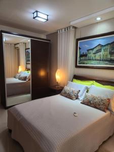a bedroom with a large bed and a large mirror at Villa Gardem in Aracaju