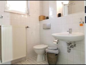 ein weißes Bad mit einem Waschbecken und einem WC in der Unterkunft Lara in Bargteheide