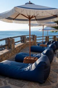 a row of blue inflatables sitting next to the ocean at Aquila Elounda Village Resort, Suites & Spa in Elounda