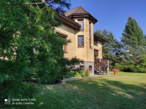 una casa con un árbol delante de ella en Ramus poilsis prie Širvintų marių en Širvintos