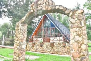 une arche en pierre devant une maison dans l'établissement Airman’s Lodge, 