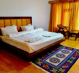 a bedroom with a large bed with a rug on the floor at Niran Boutique Hotel in Leh +16 photos