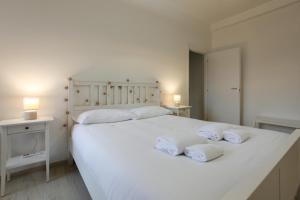 Un dormitorio con una cama blanca con toallas. en Splendido Bilocale sul Naviglio Grande, en Corsico