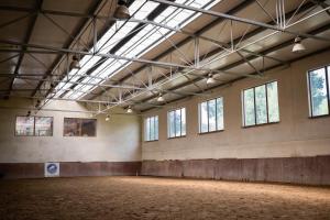 an empty room with windows and a large room with a large floor at Lascalla pensjonat in Myszewko