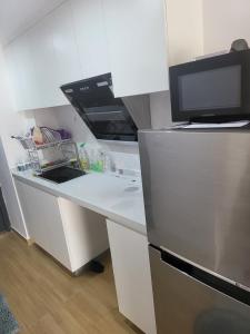 a kitchen with a sink and a refrigerator at Morgan enmaison in Phnom Penh