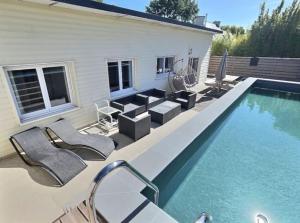 Kerlouan的住宿－Ty inizi : Maison avec piscine，一座房子旁的游泳池,配有躺椅