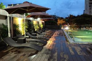 - une rangée de chaises et de parasols à côté de la piscine dans l'établissement Dragon Sea Hotel, à Sầm Sơn