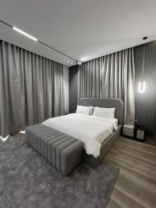 1 dormitorio con 1 cama grande en una habitación con cortinas en Sea Breeze Villa, en Fujairah