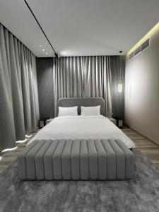 1 dormitorio con 1 cama grande en una habitación con cortinas en Sea Breeze Villa, en Fujairah
