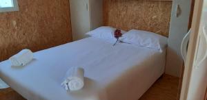 a white bed with a flower on top of it at Parque de Campismo da Praia da Barra in Gafanha da Nazaré