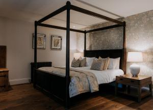 um quarto com uma cama de dossel e uma mesa em The Ferry House em Eastchurch