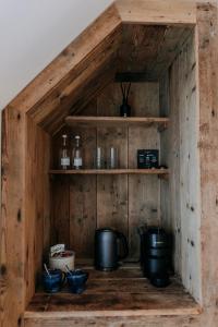a wooden cabinet with some pots and pans on it at The Harty Estate in Eastchurch