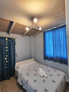 sypialnia z łóżkiem z niebieskimi zasłonami w obiekcie Vasiliki house 1 w mieście Vartholomión