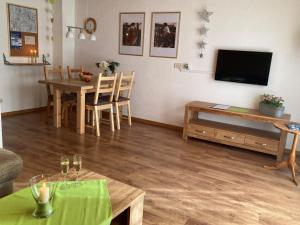 a living room with a table and a television at Haus Petra und Toni Holzheu in Bad Hindelang