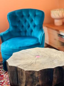 uma cadeira azul e uma mesa de café com um toco de árvore em Apartament Lakshmi- Villa Vinci em Jelenia Góra