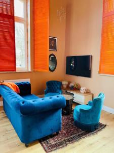 a living room with a blue couch and two chairs at Apartament Lakshmi- Villa Vinci in Jelenia Góra