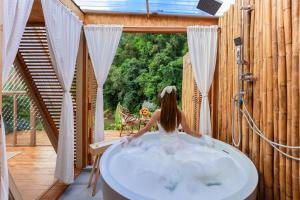 a woman sitting in a bath tub in a house at บ้านธารหมอก แอท สะปัน in Ban Huai Ti +19 photos
