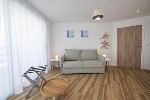 uma sala de estar com um sofá e um piso de madeira em MY HOTEL Residences em La Grande-Motte