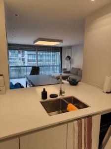 a kitchen with a sink and a living room at Vanbunnen in Knokke-Heist
