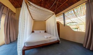 a bed in a room with a mosquito net at Red Sands Pool Villa in Phan Thiet