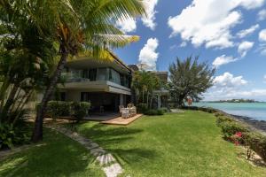 une maison sur la plage avec des palmiers dans l'établissement Beautiful 3 bed-room beachfront penthouse, à Grand Baie