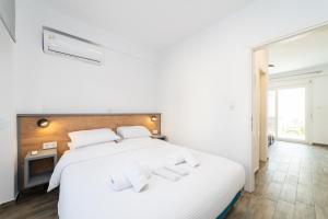 - une chambre avec un grand lit blanc et des oreillers blancs dans l'établissement Kleoniki & Irida Residential Complexes, à Ofrynio