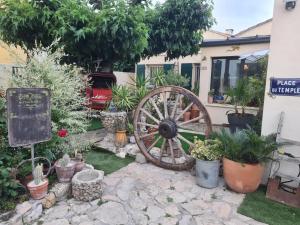 a garden with a wheel and plants in front of a house at rez de maisons in Avignon