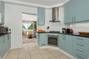 a kitchen with blue cabinets and a stove top oven at 58 Kreef Lane in Cape Town