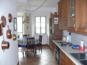 a kitchen with wooden cabinets and a table with chairs at Appartamento Olga in Stresa