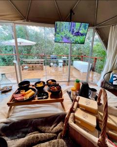 a table with food on it in a tent at GOAT LODGE Domo Pitanga in Ibiúna