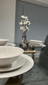 uma mesa com pratos e um vaso com flores em City Apartment 2 bed 2 bath- Netflix - Off-Street Parking - Wifi em Birmingham