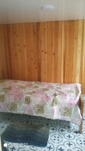 um quarto com uma cama e uma parede de madeira em Family Holiday em Kobuleti